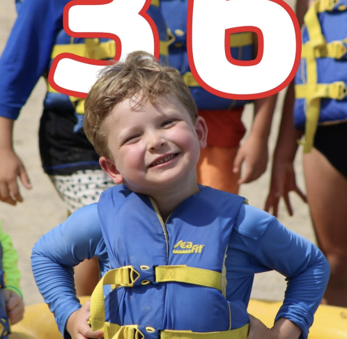 Young camper in life jacket at the waterfront